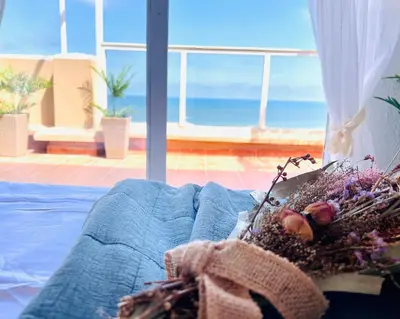 a bed in a room with a view of the ocean at Lux Penthouse Mediterranean views Beach front in Puerto de Sagunto