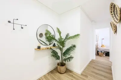 a palm tree in a room with a mirror at Lux Penthouse Mediterranean views Beach front in Puerto de Sagunto