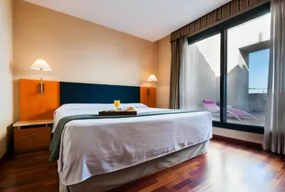 a hotel room with a large bed and a large window at Hotel Villacarlos in Valencia