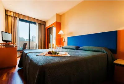 a hotel room with a bed with a tray of wine glasses at Hotel Villacarlos in Valencia