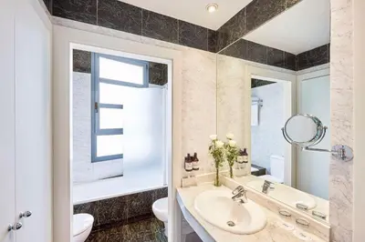 a bathroom with a sink and a toilet and a mirror at NH Valencia Las Artes in Valencia