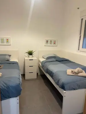 a bedroom with two beds and a dresser at UIM Mediterraneo PB Libertad Wifi in Puerto de Sagunto