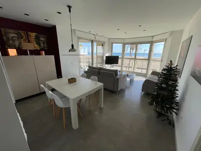 a living room with a white table and a christmas tree at PRIMERA LINEA PLAYA PATACONA, VALENCIA in Valencia