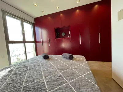 a bedroom with red walls and a large bed at PRIMERA LINEA PLAYA PATACONA, VALENCIA in Valencia