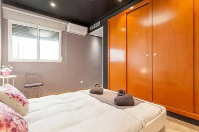 a bedroom with a large bed and a wooden cabinet at PENTHOUSE on the BEACH in Valencia