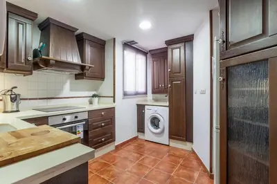 a kitchen with wooden cabinets and a washing machine at PENTHOUSE on the BEACH in Valencia