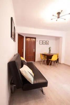 a living room with a black couch and a table at Marina Flat by Concept Flats in Valencia