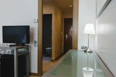 a hotel room with two beds and a window at Hotel Mas Camarena in Paterna