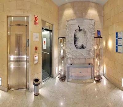 a lobby with a potted plant in the middle of a building at Hotel Mas Camarena in Paterna