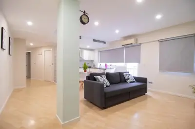 a living room with a couch and a clock on a wall at Old Town Flat by Concept Flats in Valencia