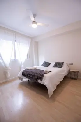 a white bedroom with a bed and a ceiling fan at Old Town Flat by Concept Flats in Valencia