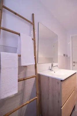 a bathroom with a sink and a mirror and towels at Old Town Flat by Concept Flats in Valencia