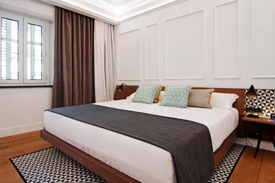 a bedroom with a large bed and a desk at One Shot Reina Victoria in Valencia