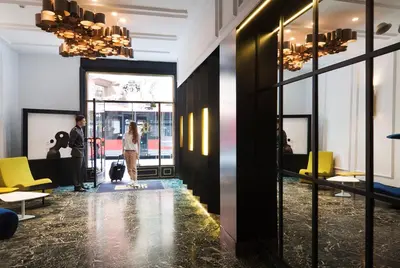 a group of people standing in a room with a lobby at One Shot Reina Victoria in Valencia