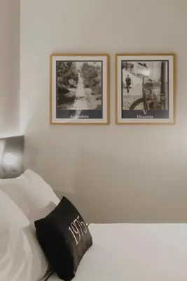 a white bed with two pictures on the wall at Hotel Dimar in Valencia