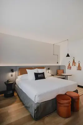 a bedroom with a large white bed and a chair at Hotel Dimar in Valencia