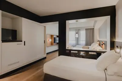 a bedroom with a bed and a living room at Hotel Dimar in Valencia