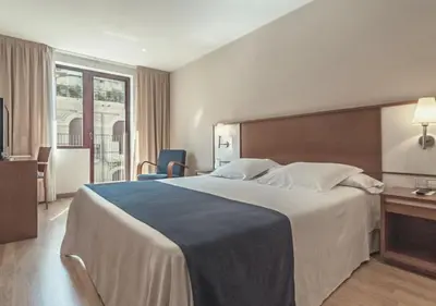 a hotel room with a large bed and a window at Hotel RH Sorolla Centro in Valencia