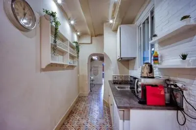 a kitchen with a counter and a clock on the wall at Lovely Coquette loft, heart of cuitat vella El Carmen Valencia in Valencia