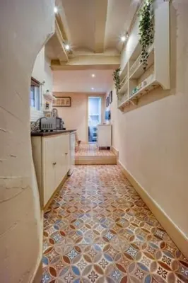 a hallway of a kitchen with a tile floor at Lovely Coquette loft, heart of cuitat vella El Carmen Valencia in Valencia