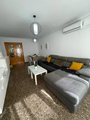 a living room with a couch and a table at UIM Mediterraneo Claveles Wifi in Puerto de Sagunto