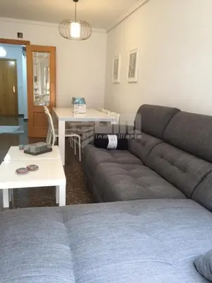 a living room with a couch and a table at UIM Mediterraneo Claveles Wifi in Puerto de Sagunto