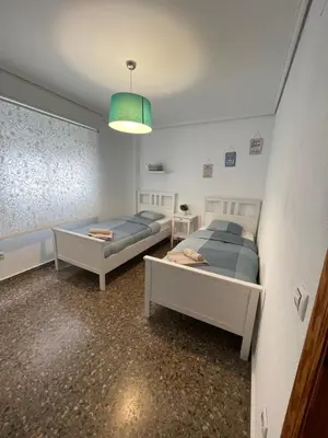 a room with two beds and a pendant light at UIM Mediterraneo Claveles Wifi in Puerto de Sagunto