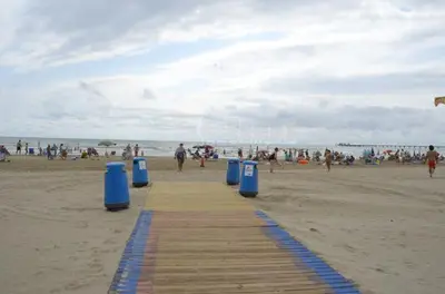 a wooden path on a beach with a crowd of people at UIM Mediterraneo Claveles Wifi in Puerto de Sagunto