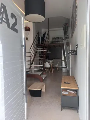a living room with a staircase and a table at Loft Nou Benicalap - Housevanlive in Valencia