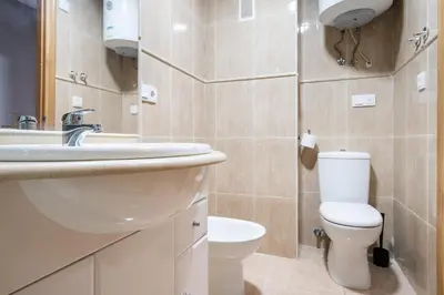 a bathroom with a white toilet and a sink at Excelente apartamento en 2ª línea de playa by Hometels in Puerto de Sagunto