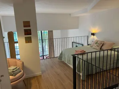 a bedroom with a bed and a chair in a room at Alameda Velvet Ciudad Ciencias - Housevanlive in Valencia