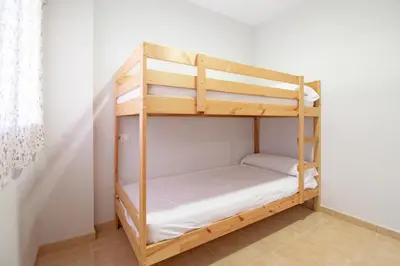 a bunk bed room with two bunk beds at Global Vacacional, Apartamento con gran terraza y piscina in Canet de Berenguer
