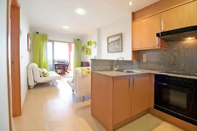 a kitchen with a sink and a stove top oven at Global Vacacional, Apartamento con gran terraza y piscina in Canet de Berenguer