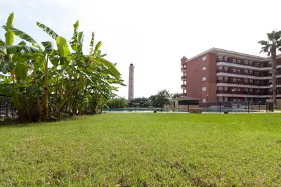 a field of grass with a building in the background at Global Vacacional, Apartamento con gran terraza y piscina in Canet de Berenguer