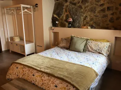 a bedroom with a bed with a stone wall at Casa Puri in Jérica