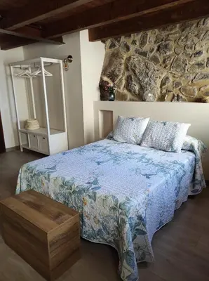a bedroom with a bed and a stone wall at Casa Puri in Jérica