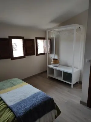 a bedroom with a bed and two windows at Casa el Recreo in Jérica