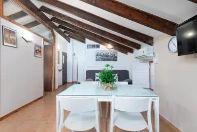 a dining room with a table and white chairs at Malvarrosa Las Arenas II in Valencia