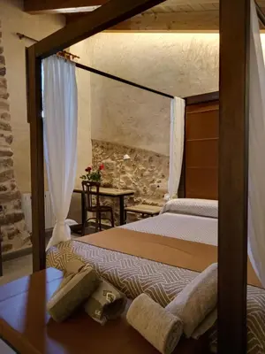 a bedroom with two beds and a table with a table sidx sidx at Casa rural El Forn d'Alcudia de Veo in Alcudia de Veo