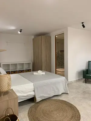 a bedroom with a large bed and a green chair at Alex- DUPLEX APARTMENT- City in Valencia