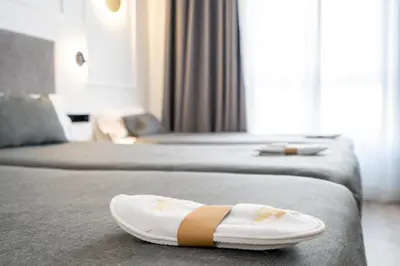 a pair of sandals sitting on the bed in a hotel room at Hotel Conqueridor in Valencia