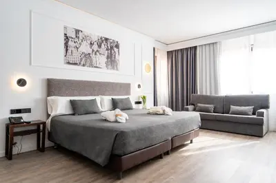 a bedroom with a large bed and a couch at Hotel Conqueridor in Valencia