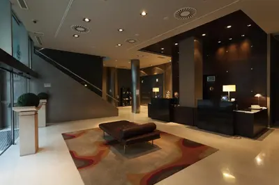 a lobby with a couch and a chair in a building at Hotel Conqueridor in Valencia
