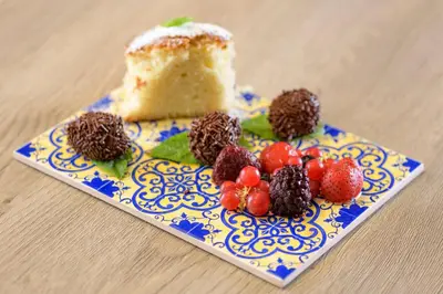 a blue and white plate with a piece of cake and berries at AC Hotel Valencia by Marriott in Valencia