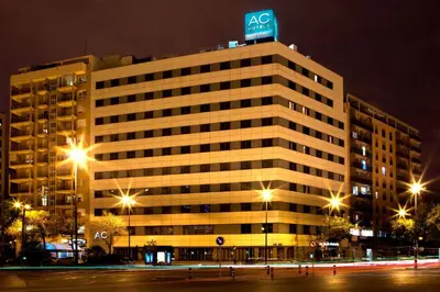 a building with a sign on top of it at night at AC Hotel Valencia by Marriott in Valencia