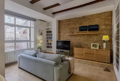 a living room with a couch and a brick wall at Enjoy Apartment 4 pax at Ruzafa with sunny terrace in Valencia