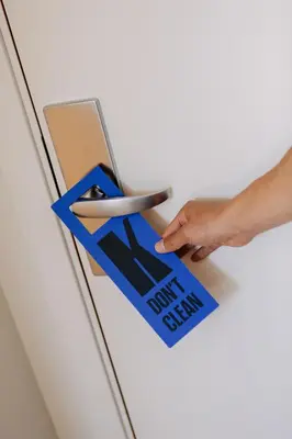 a person inserting a now finished sign into a door at Hotel Kramer in Valencia