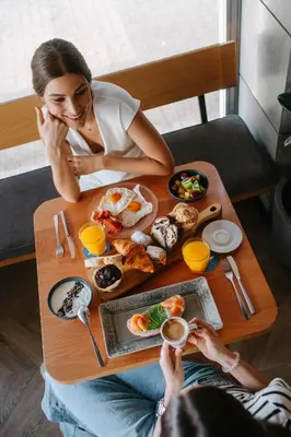 a woman sitting at a table with a plate of food at Hotel Kramer in Valencia