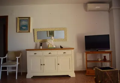 a living room with a television and a white cabinet at Apartamento Florazar 2, 10ºC Cullera in Faro de Cullera