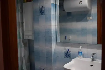a bathroom with a toilet and a sink and a mirror at Apartamento Florazar 2, 10ºC Cullera in Faro de Cullera